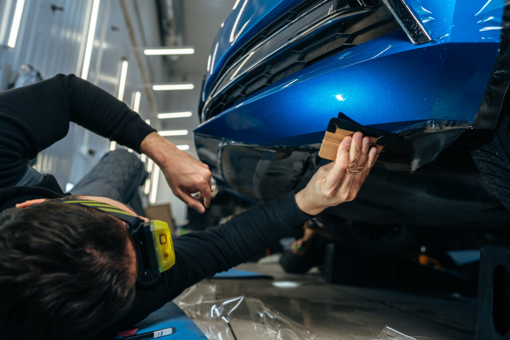 a man working on a blue car